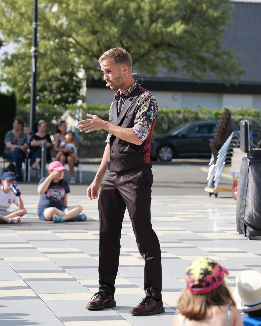 eligius magie en spectacle dehors dans la rue avec des enfants autour de lui