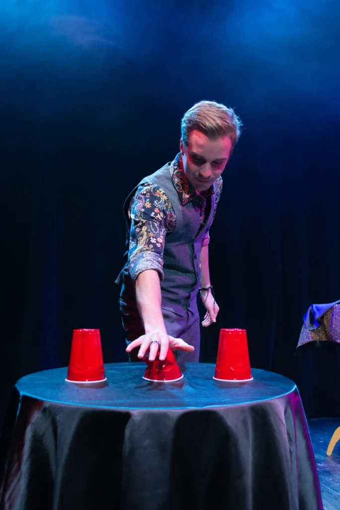 eligius qui fais un tour en écrasant un verre rouge sur une table